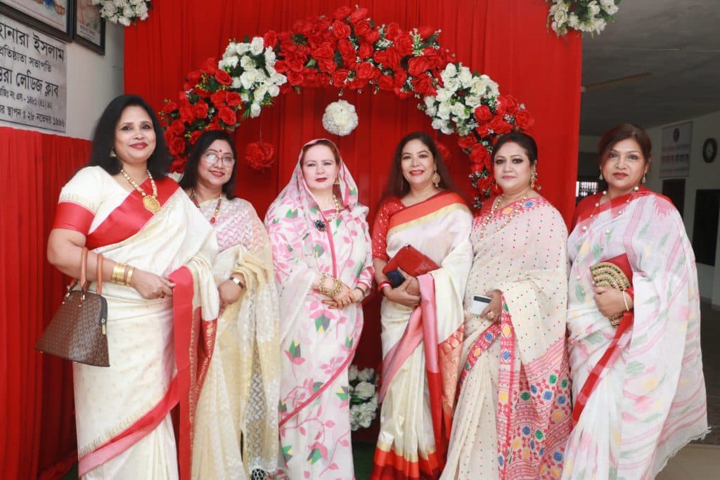 Uttara Ladies Club members in front of floral backdrop